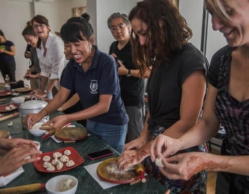 Travelers enjoying their participation in cooking class while also learning about the project